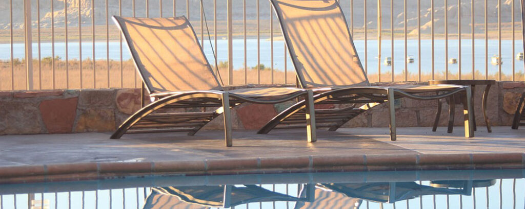 Dos tumbonas de jardín exterior junto a una piscina