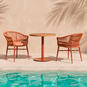 Mobiliario de terraza de hotel con sillones Melbourne Terracota y mesa redonda contract junto a piscina