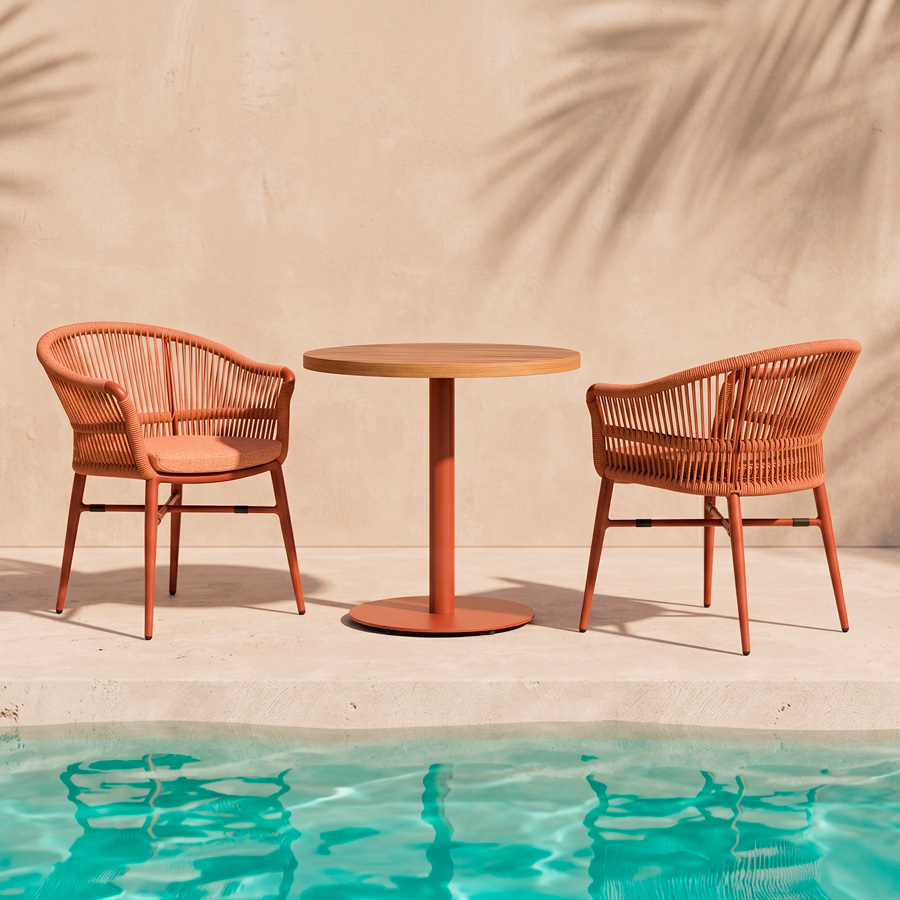 Mobiliario de terraza de hotel con sillones Melbourne Terracota y mesa redonda contract junto a piscina